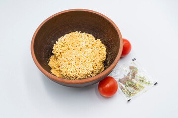 Instant pasta with herbs and spices in a bowl on a white background.