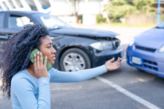 Black woman calling insurance support after car crash