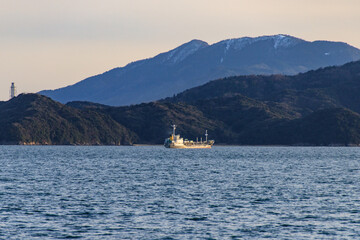Serene Maritime Landscape with a Ship and Mountainous Backdrop