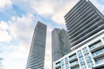 Modern residential high-rises stand tall against a partly cloudy sky, showcasing sleek...