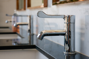 sleek chrome faucet installed on a polished black marble counter