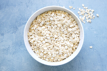 Oat flakes bowl on blue background
