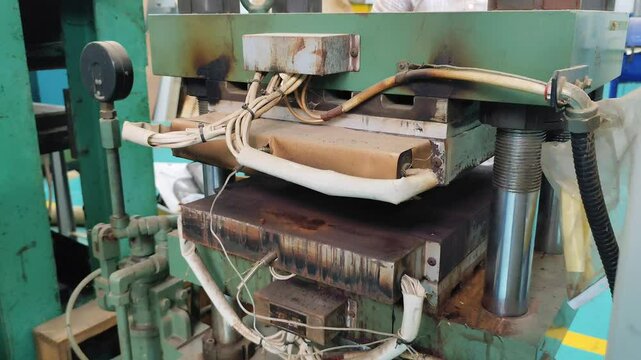 Hydraulic hot press machine video with heating plate, industrial compression equipment, manufacturing tool for precise molding, featuring metal plates, hydraulic system, and pressure mechanism