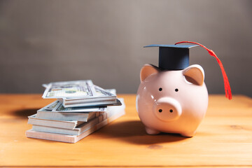 Piggy bank with graduation hat and money
