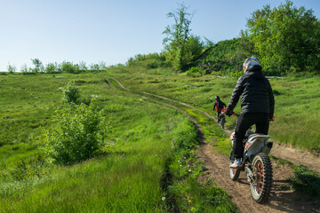 Naklejka premium A man is riding a dirt bike on a trail in a grassy field