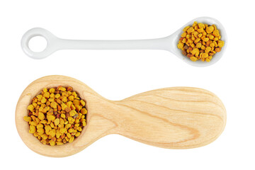 Bee pollen grains in wooden and ceramic spoon isolated on white background. Top view. Flat lay