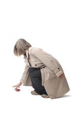 side view of a woman picking up a cigarette pack on the floor on white background