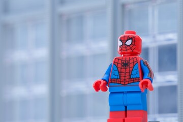 Naklejka premium Tambov, Russian Federation - January 24, 2025 Lego Spiderman minifigure standing in front of an office building