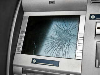 Close-up a broken ATM on a city street with a broken screen.