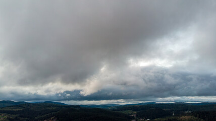 Magnificent Aerial View Of Mountains And Dense Forests Under Dark Clouds, With Raindrops Falling, Creating A Dramatic And Serene Atmosphere In A Remote Natural Landscape.	
