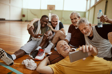 Senior men taking group selfie after basketball game