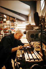 Mechanic working on precision machinery in workshop