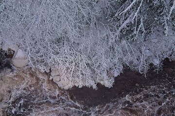 Winter river landscape, snow covered branches, Nukarinkoski, Nurmijärvi, Finland.