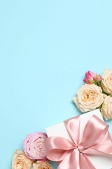Beautiful composition with roses with gift box on color background 