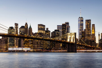 Naklejka premium A panoramic sunset view of the Brooklyn Bridge stretching towards Manhattan