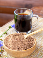 Ground chicory root, chicory flowers and chicory drink on a rustic wooden background. Alternative medicine. Healthy drinks