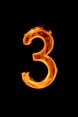 a close up of a fire number three on a black background