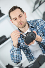 young photographer cleaning camera