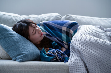 冬にソファで眠る日本人女性