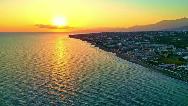 A stunning golden sunset over &Pi;&alpha;&rho;&alpha;&lambda;ί&alpha; &Alpha;&nu;ά&lambda;&eta;&psi;&eta;, Chersonisos, Greece, coastal town view
