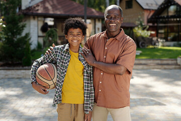 Smiling African American Boy Holding Basketball Outdoors
