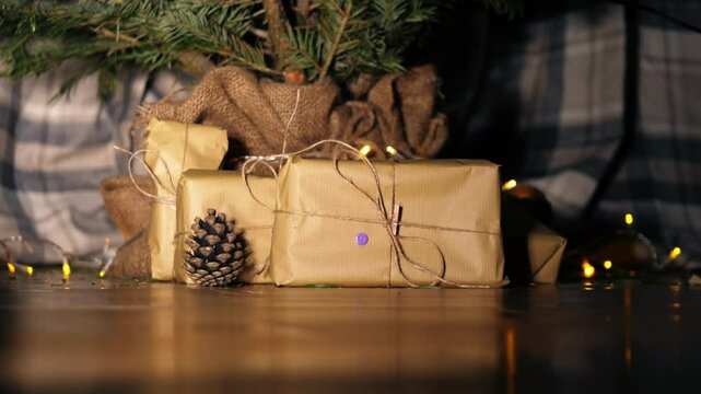 Gift wrapped in brown paper and string with Christmas lights bokeh background