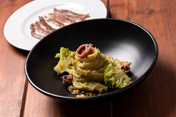 Piatto di linguine con crema di broccoli e alici, pasta italiana, ricetta mediterranea 