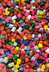 Lots of small pieces of multi-colored plastic, line for the production of plastic products or recycling