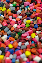 Lots of small pieces of multi-colored plastic, line for the production of plastic products or recycling