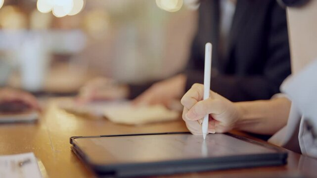 A person is writing on a tablet with a white pen. Concept of productivity and focus, as the person is engaged in a task that requires concentration and attention to detail