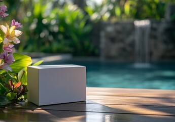 White box on wooden deck by poolside with flowers and waterfall in tropical garden