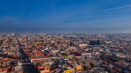 Aerial photography of the Nevado de Toluca landscape at sunset, with snow, clouds and a sky with ochre and red colors can be seen, in addition to a view of the magical town of Metepec.