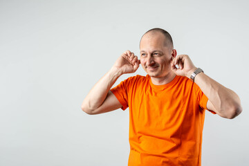 Stressed mature man covers his ears with his hands