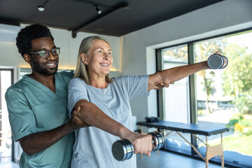 Man chiropractor in hospital assisting mature woman with pain relief exercises for physical recovery