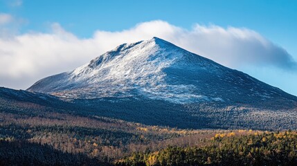 Fototapeta premium A photo of a mountain peak, the first signs of snow dusting its slopes as the winter season approaches.