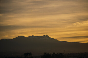 Landscape of the Nevado de Toluca at sunset, with snow, clouds and a sky with ochre and red colors...