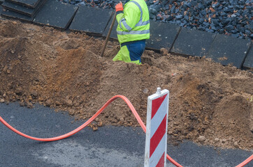 Konzept Glasfaserausbau, Internet, Kommunikation und: Arbeiter bei Baumaßnahmen für die Verlegung...