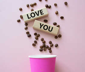 Love you symbol. Concept word Love you on wooden blocks. Beautiful pink background with coffee cup. Business and Love you concept. Copy space