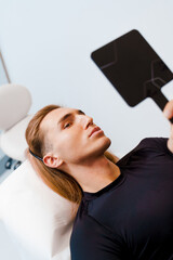Man lips augmentation and contour plastic of jawline cosmetic procedure in the clinic. Correction...