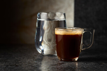 Espresso and glass of cold water on a black background.