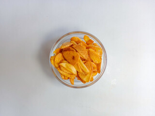 Fried garlic chips or slice on white bowl. Use as condiment topping in various Indonesian culinary meal.