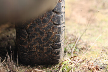Pickup truck in mud, off-road tires, close-up. Car wheel on dirt road, dry grass. Mud splashes on the side of the pickup. Adventure, outdoors in autumn. Off-road vehicle, adventure. Pickup truck step