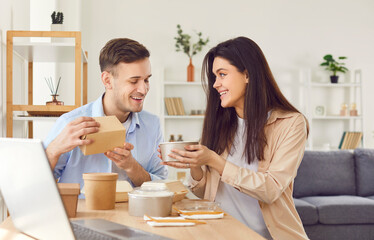 Portrait of happy couple enjoying delicious food delivered in eco-friendly packaging. Couple at...