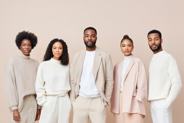 Group of young African American adults in beige attire standing against neutral background