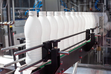 Plastic bottles on an industrial conveyor belt in a modern manufacturing facility