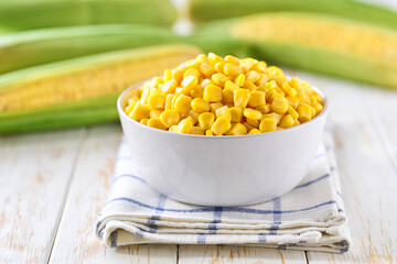 canned food maize in a white ceramic bowl on a white kitchen table, selective focus.