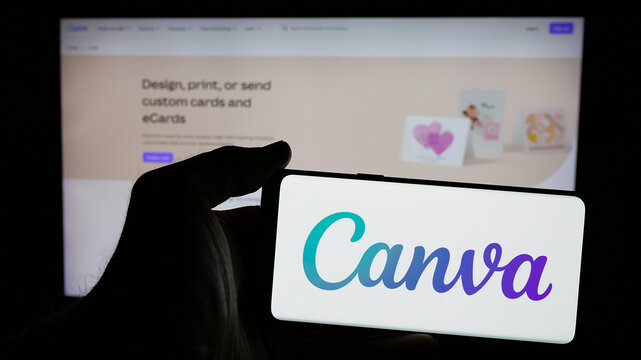 Stuttgart, Germany - 01-24-2025: Person holding mobile phone with logo of Australian graphic design company Canva Pty. Ltd. on screen in front of web page. Focus on phone display.