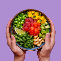 Poke bowl with salmon and tuna in hand on a purple background