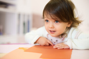 little child girl sitting at the table at home, child development.