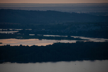 Serene twilight over Vilga river, capturing reflections and tranquil landscapes near distant hills